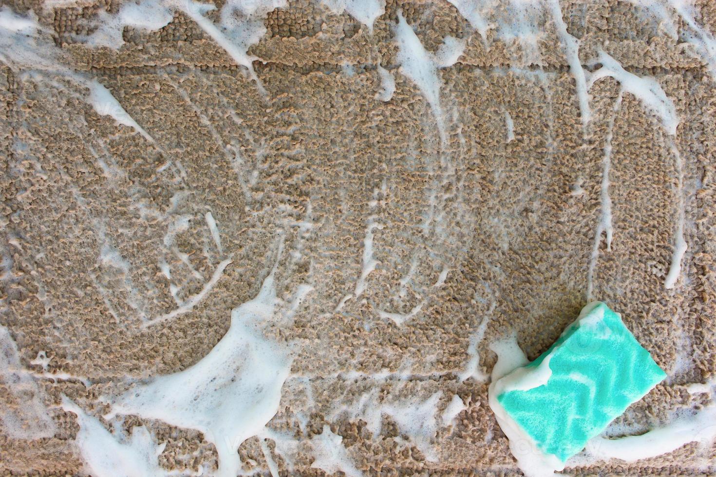 Carpet with a sponge and detergent. Top view, flat lay. photo