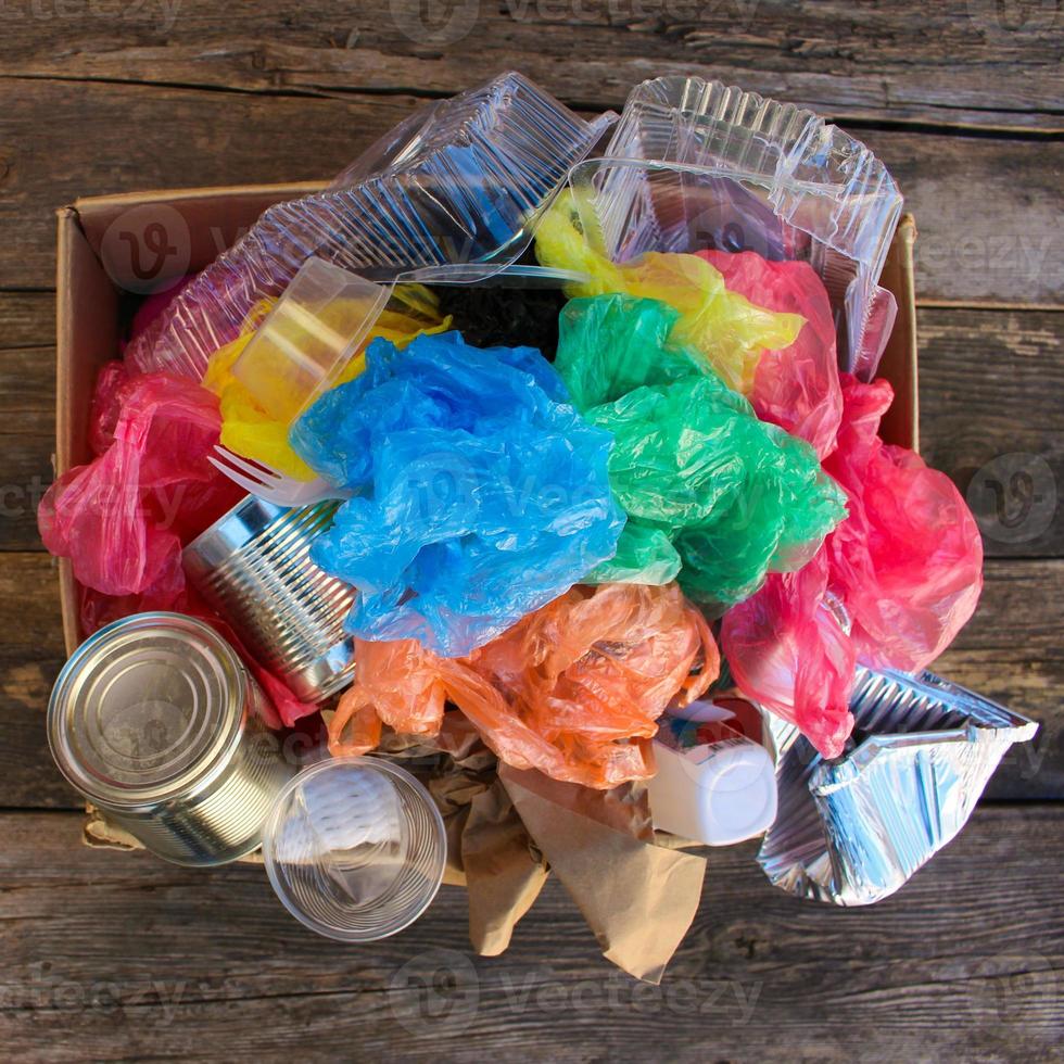 Box with trash on wooden background photo