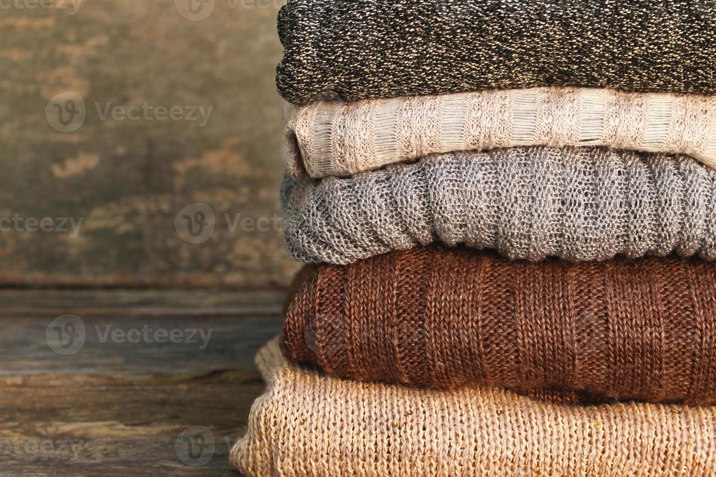 Pile of colorful warm clothes on wooden background. photo