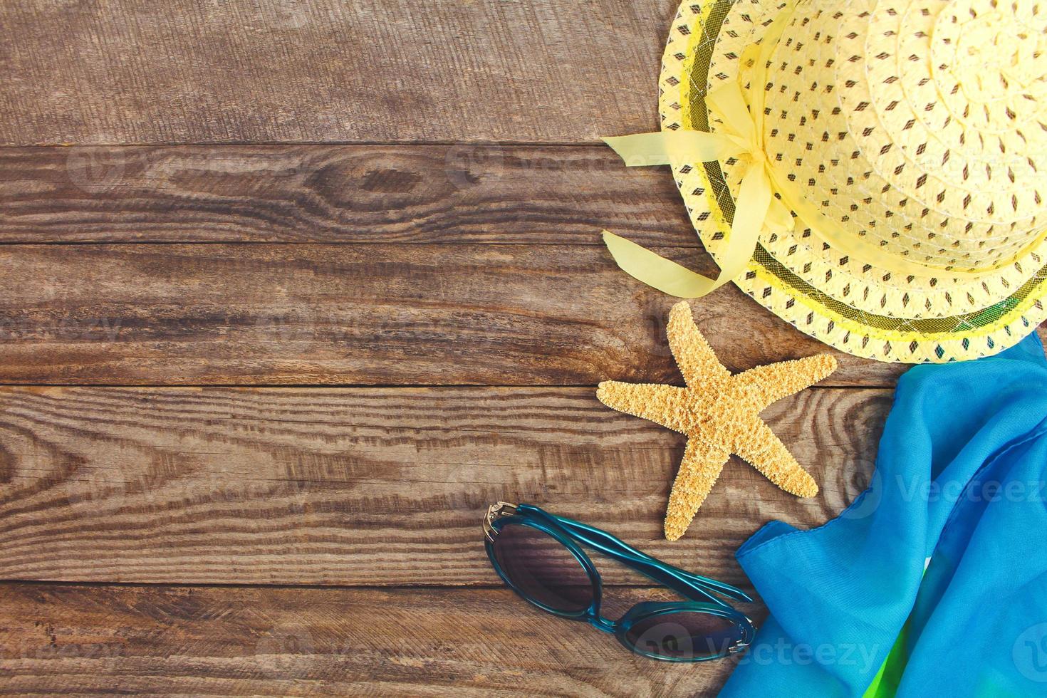 Summer accessories on wooden old background. Top view. Toned image. photo