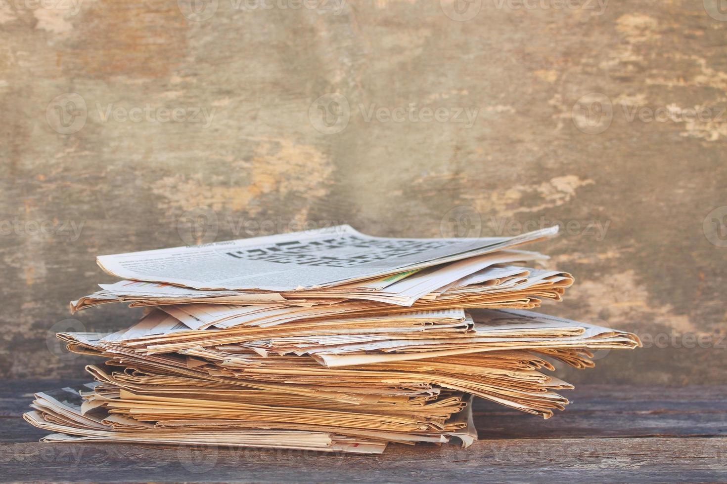 Newspapers and magazines on old wood background. Toned image. photo