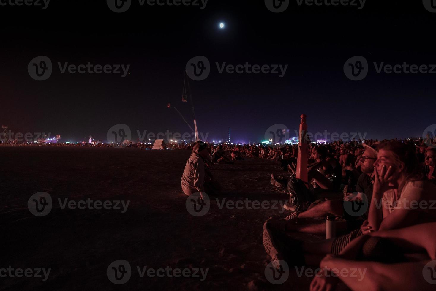 People walking towards sunset at a festival in the desert at the Burning Man Festival. photo