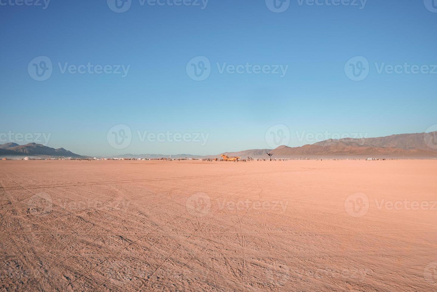 People walking towards sunset at a festival in the desert at the Burning Man Festival. photo