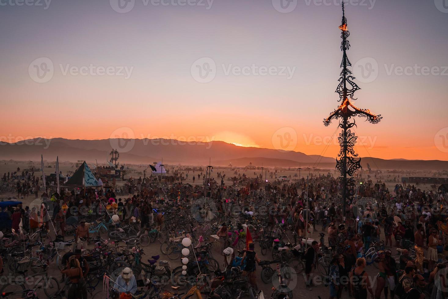People walking towards sunset at a festival in the desert at the Burning Man Festival. photo