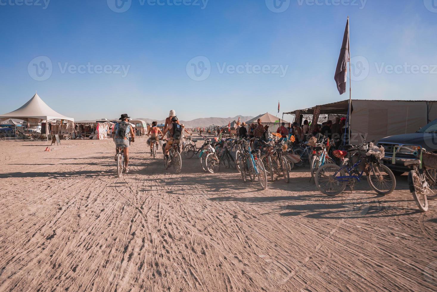 People walking towards sunset at a festival in the desert at the Burning Man Festival. photo