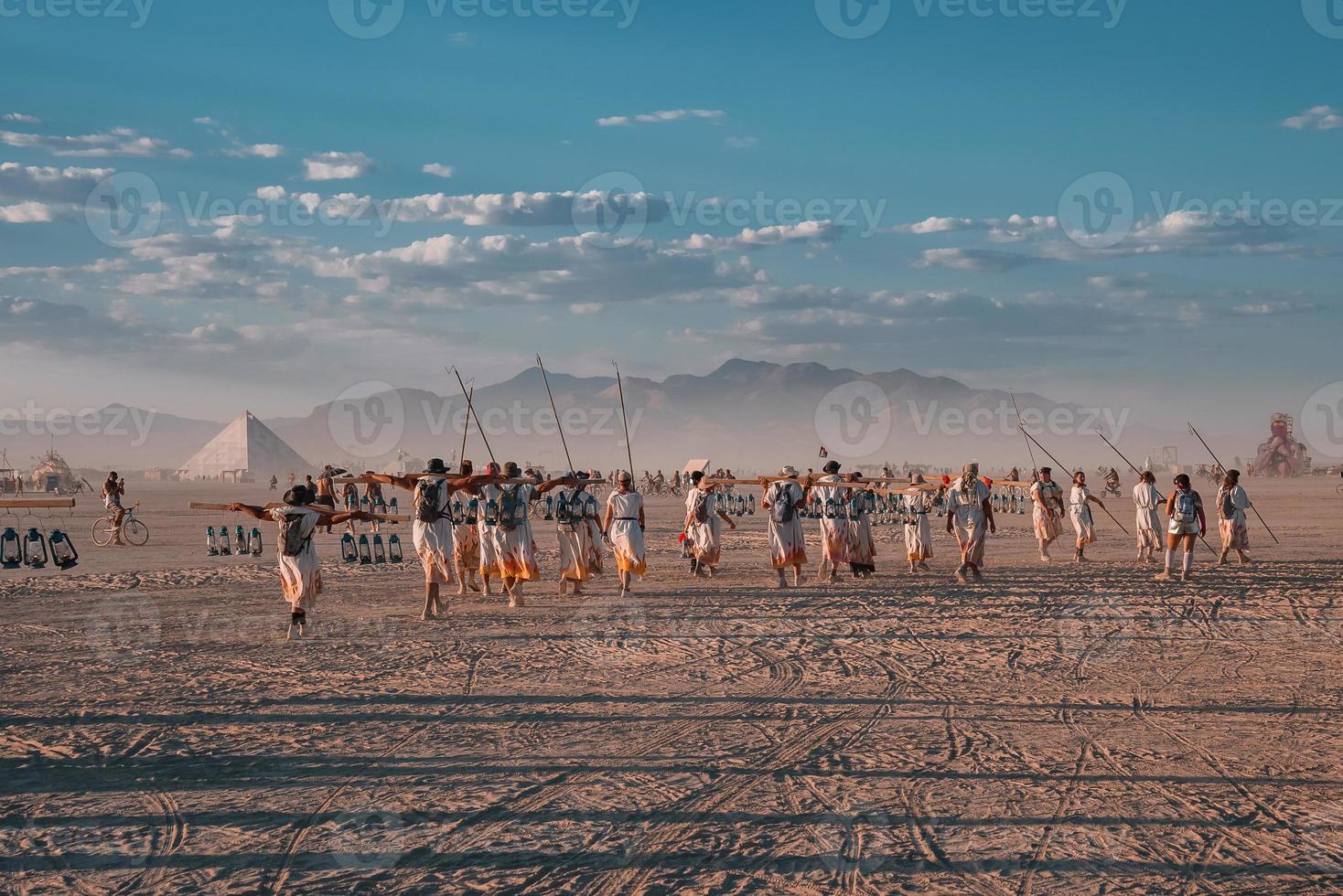 People walking towards sunset at a festival in the desert at the Burning Man Festival. photo