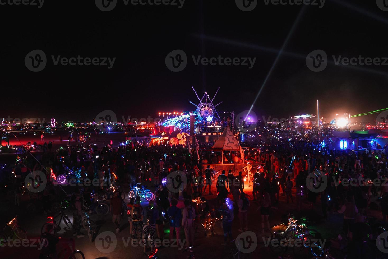 People walking towards sunset at a festival in the desert at the Burning Man Festival. photo