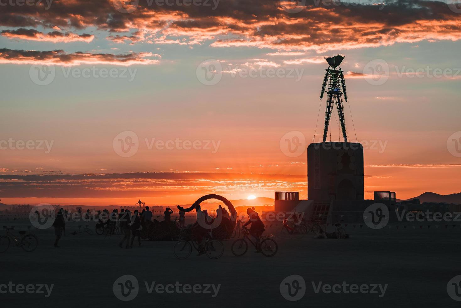 People walking towards sunset at a festival in the desert at the Burning Man Festival. photo