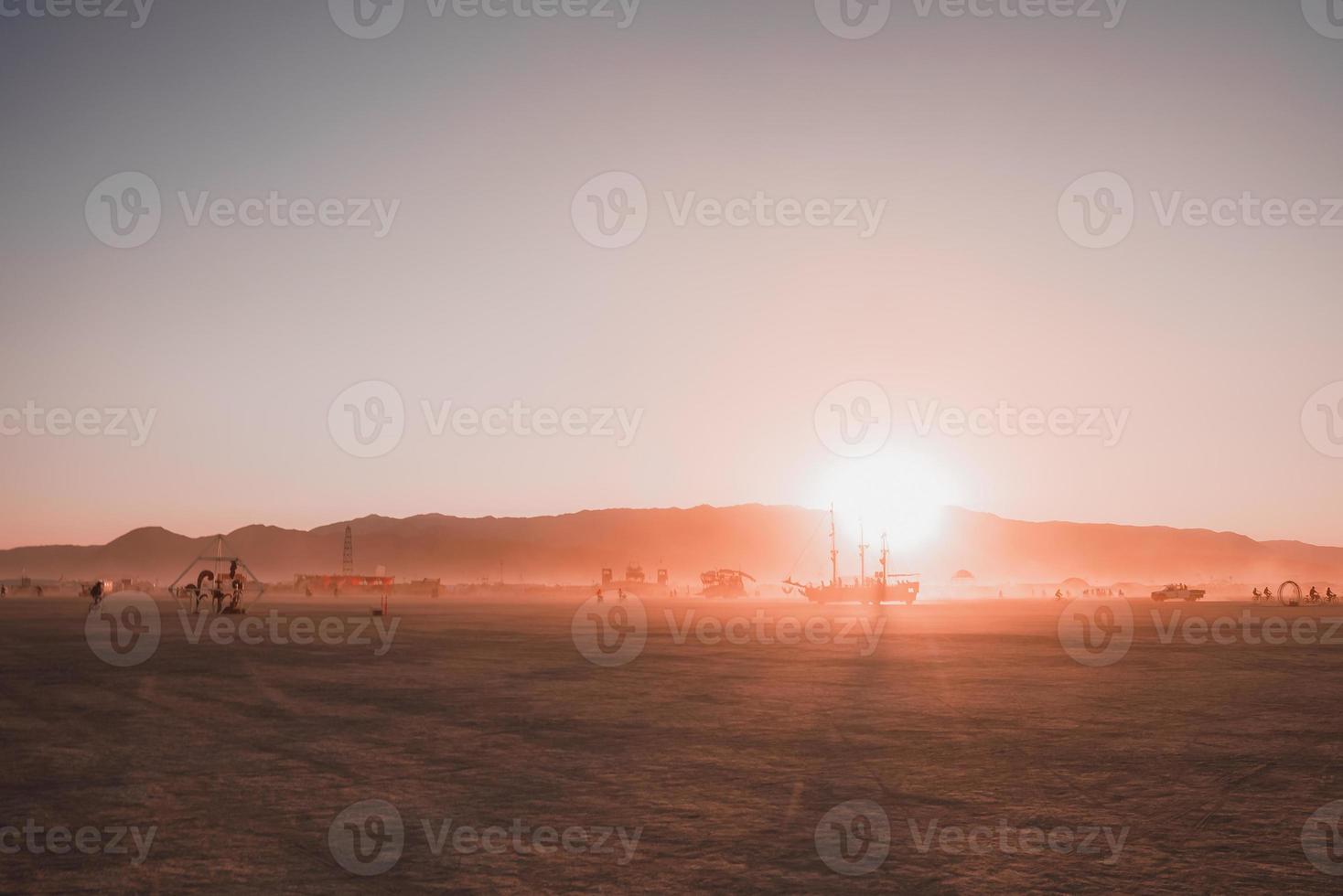 People walking towards sunset at a festival in the desert at the Burning Man Festival. photo