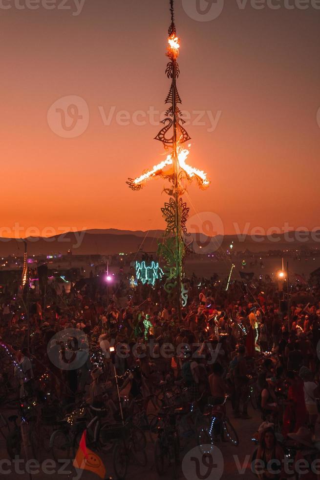 People walking towards sunset at a festival in the desert at the Burning Man Festival. photo