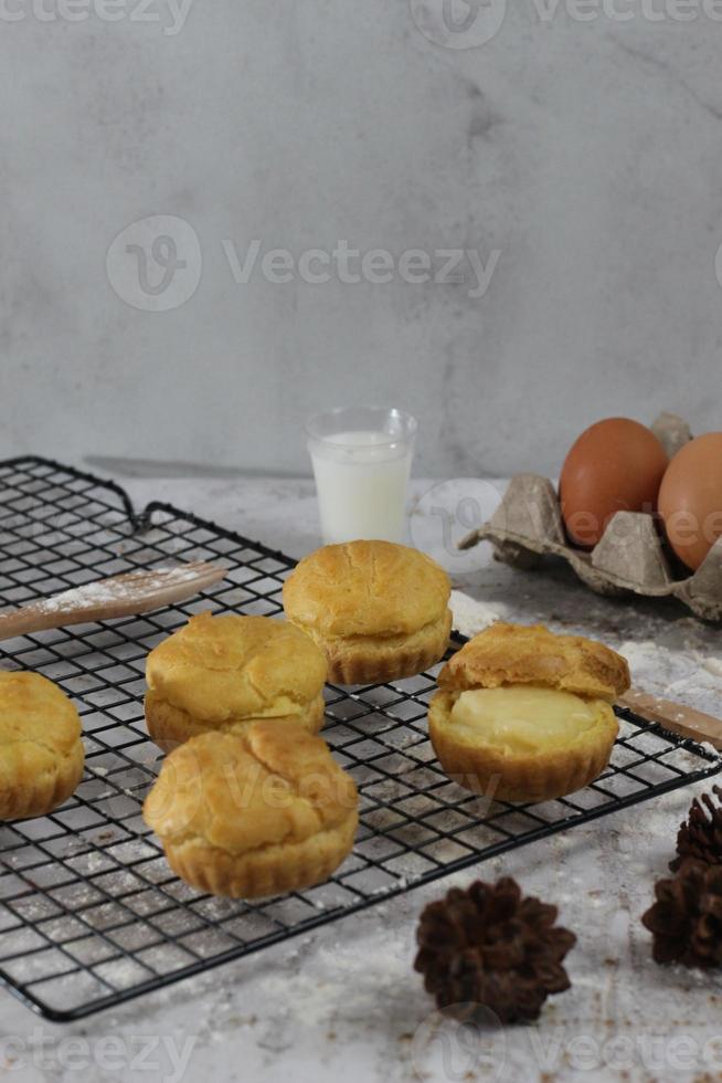 a traditional cake from Indonesia called kue sus filled with cream puffs. served on a cake rack. Food concept photo. photo