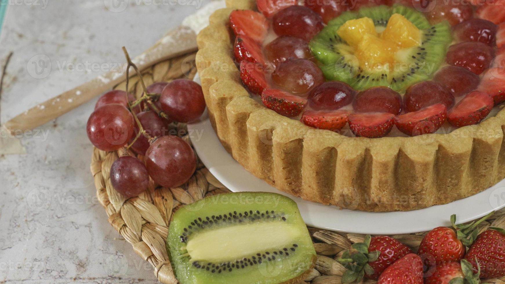 big fruit pie with toppings of strawberries, grapes, kiwi and pineapple. savory, sweet and fresh. Food concept photo. photo