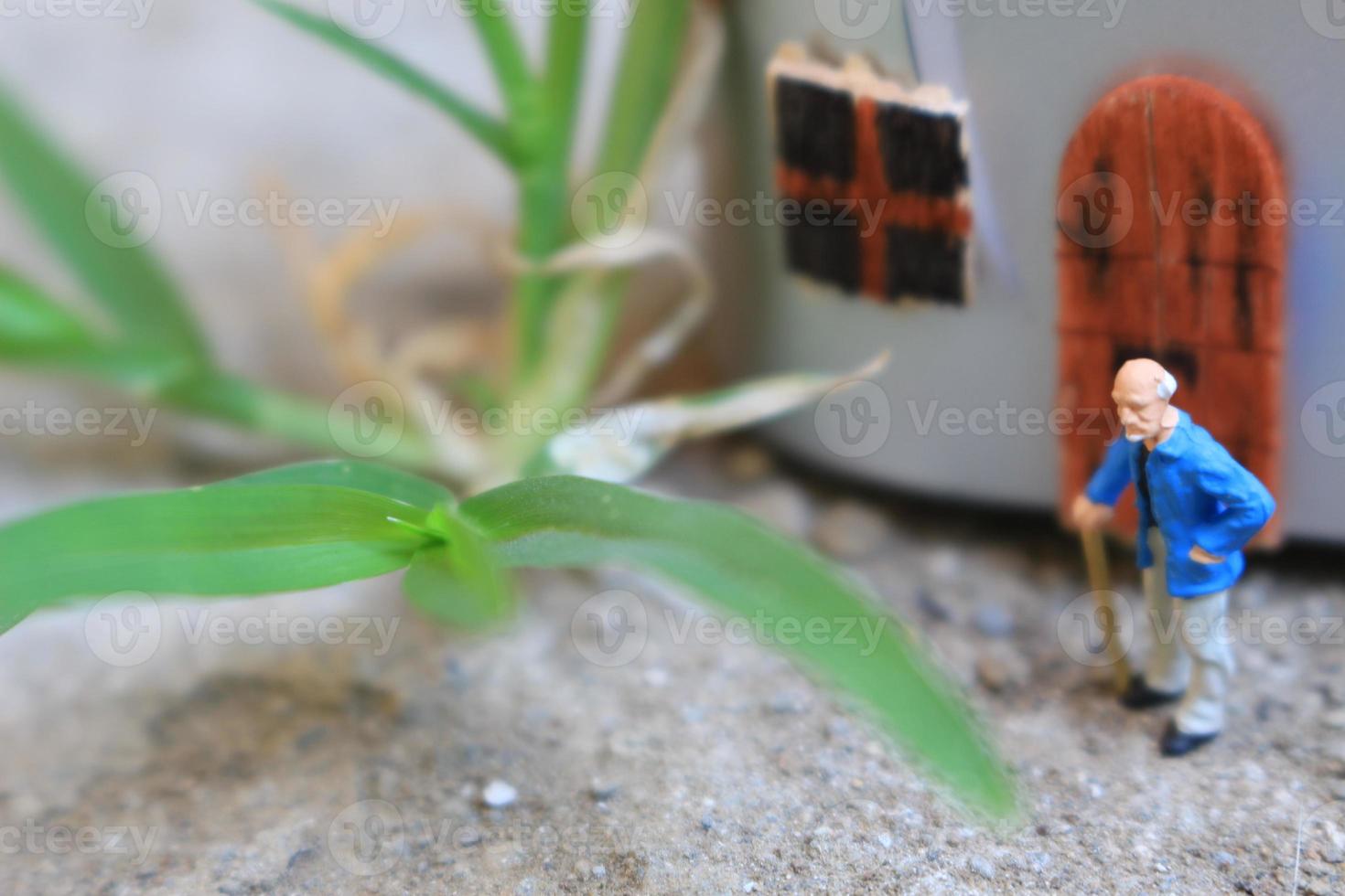 miniature figure of a grandfather who is waiting in front of the house. photo