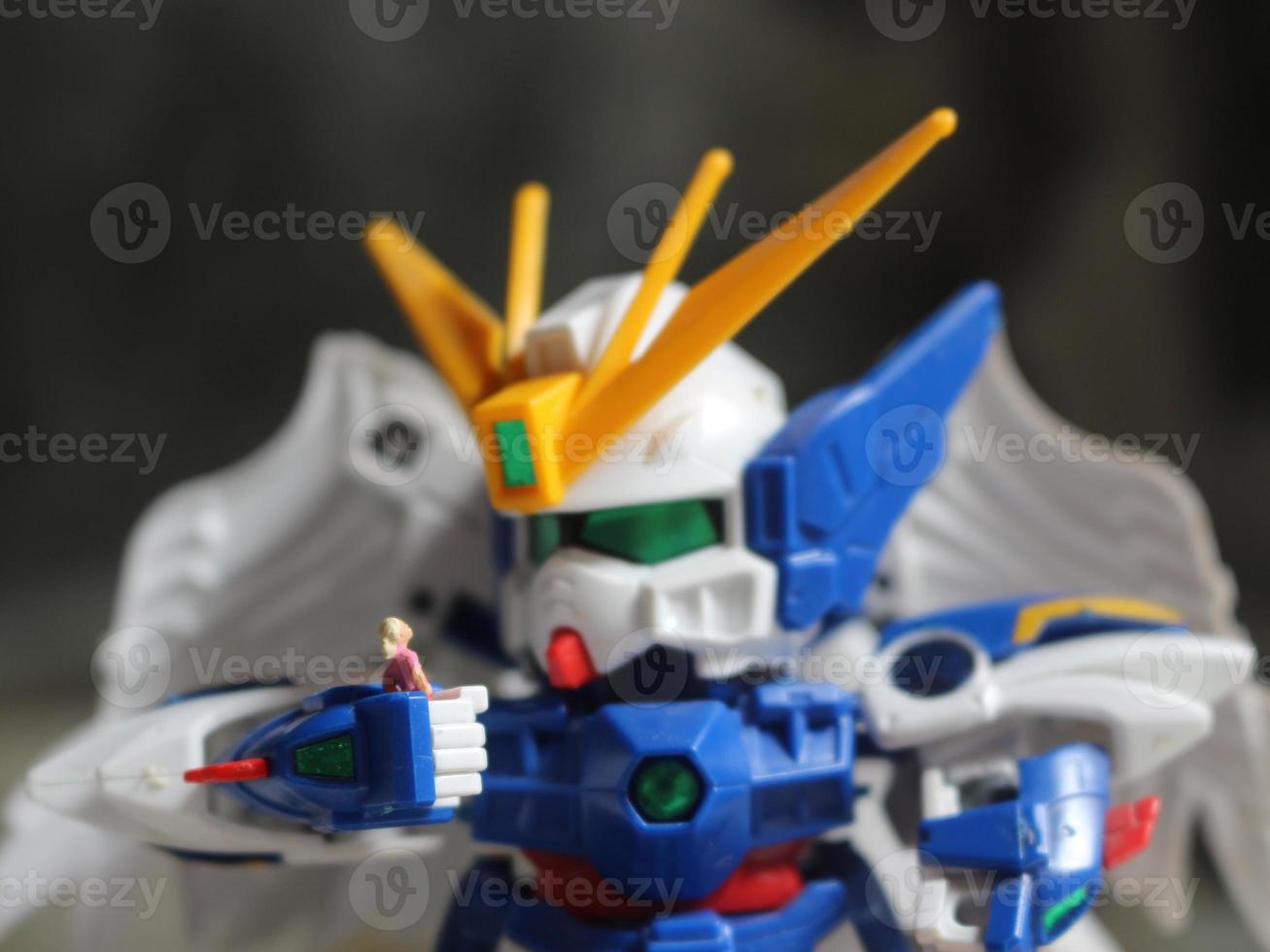 a miniature figure of a girl holding the robot's hand and looking at each other. photo