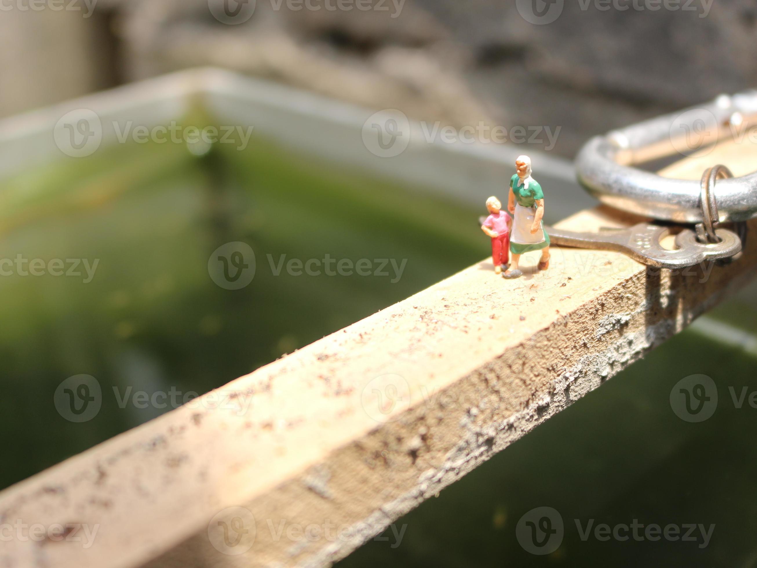 miniature figures of mother and child walking on a fish pond