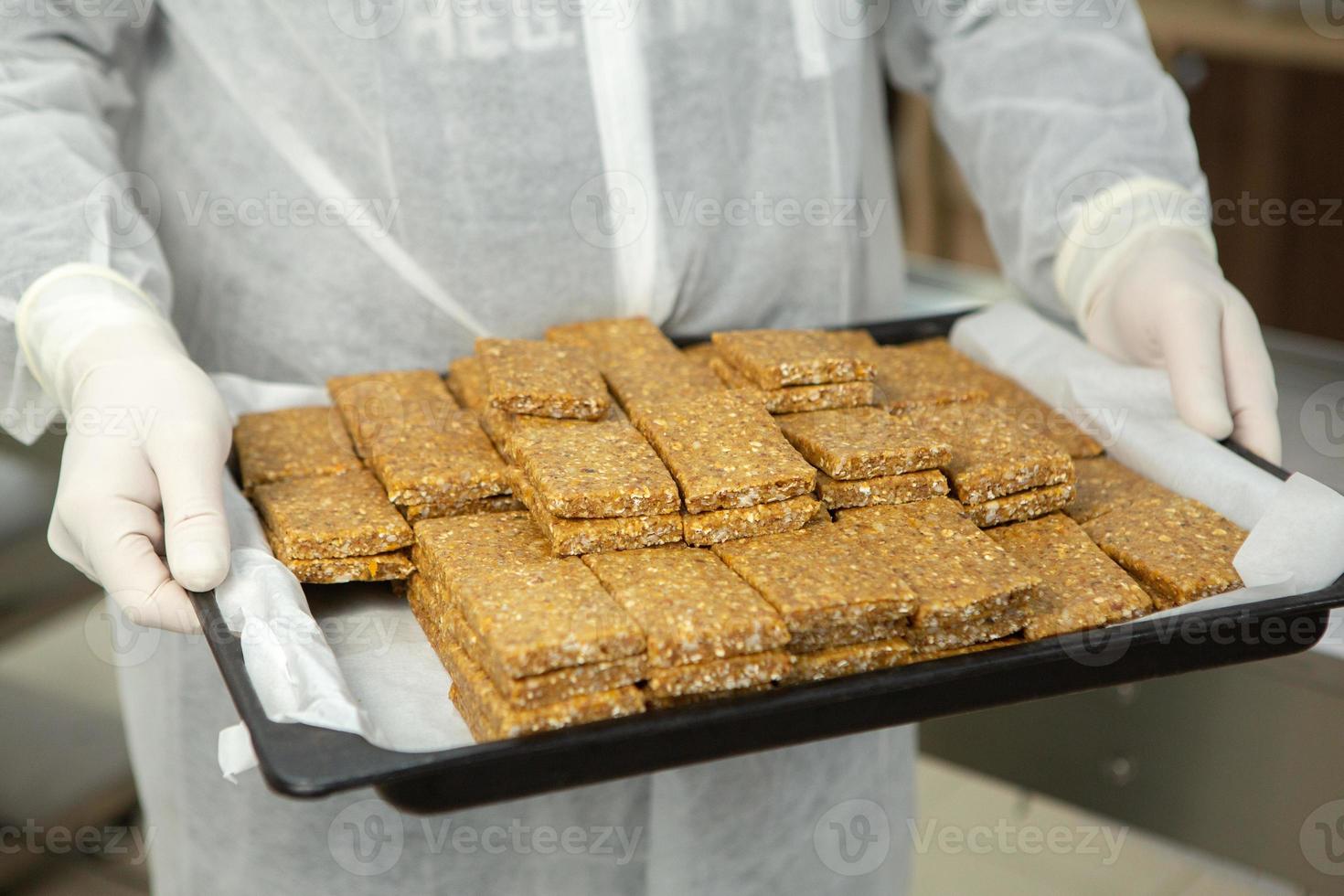 Assortment of cereal or protein bars that leave the assembly line at the factory. Healthy pre or post workout snacks with fruits, nuts and berries. photo