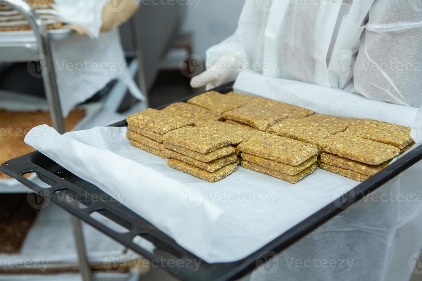 Assortment of cereal or protein bars that leave the assembly line at the factory. Healthy pre or post workout snacks with fruits, nuts and berries. photo