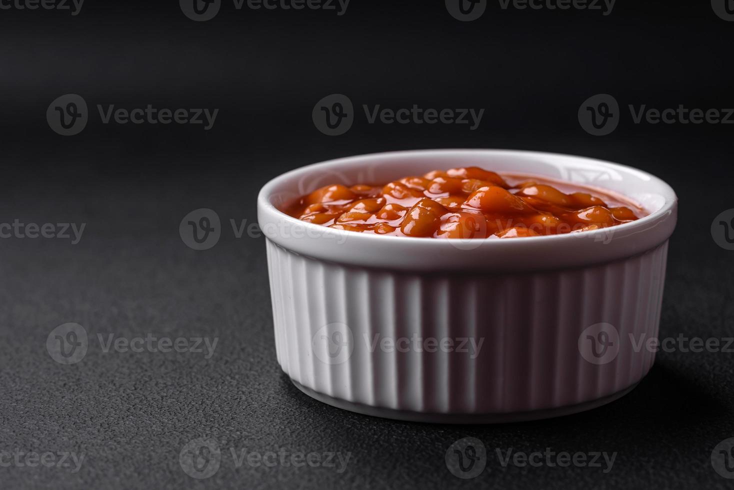 Delicious canned beans in a tomato in a white ceramic bowl photo