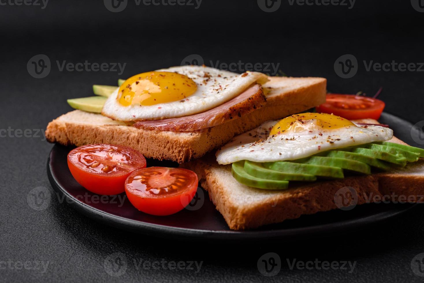 Delicious nutritious English breakfast with fried eggs, tomatoes and avocado photo