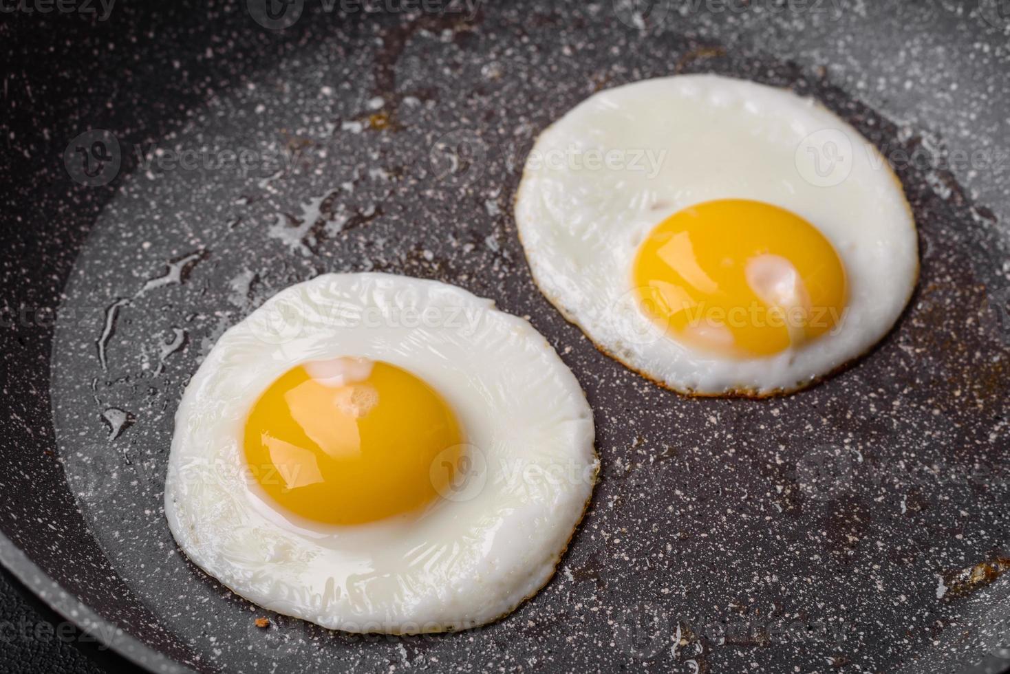 Delicious nutritious English breakfast with fried eggs and tomatoes photo