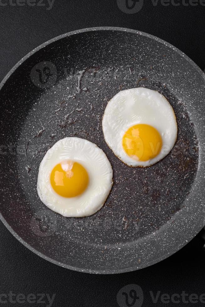 Delicious nutritious English breakfast with fried eggs and tomatoes photo