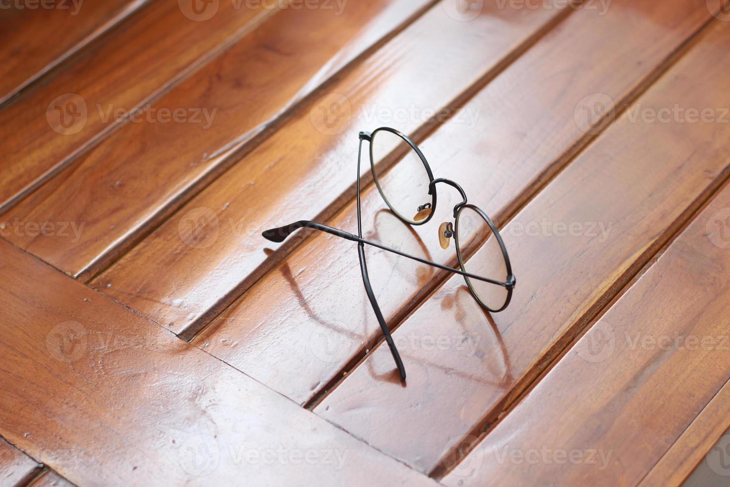 a close up of eyeglasses with black frames isolated natural patterned wooden background. photo