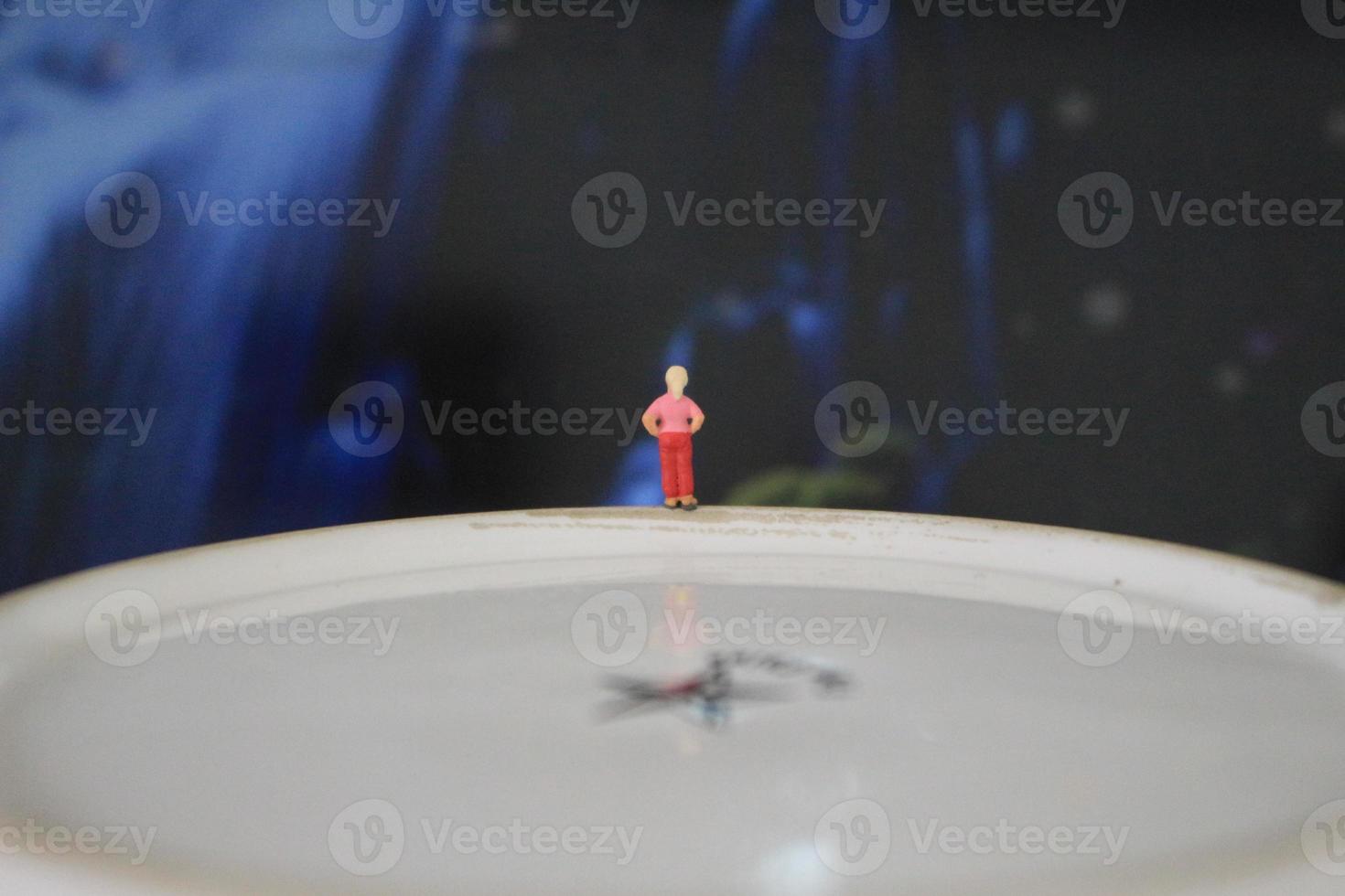 miniature figure of a child looking up at the mountains made of a plate and some cakes. photo