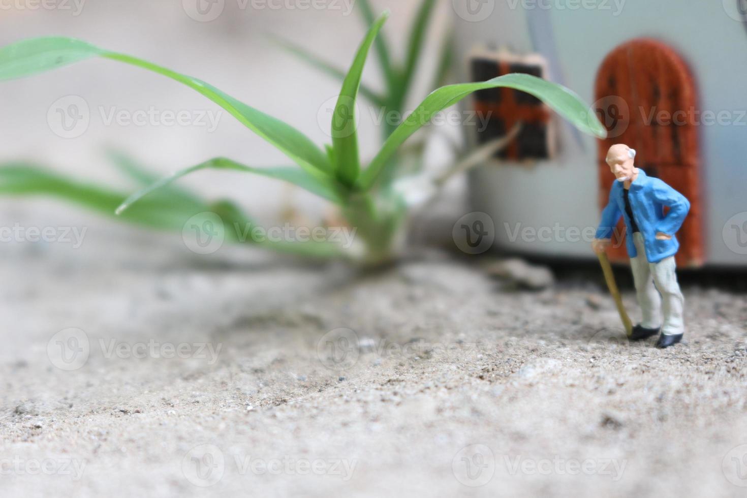 miniature figure of a grandfather who is waiting in front of the house. photo