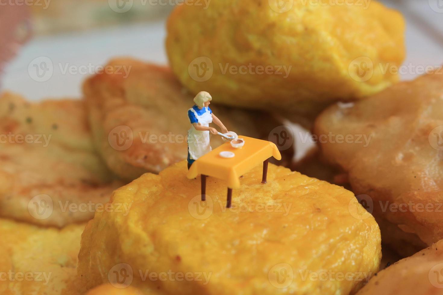 miniature figure of a mother cooking on yellow tofu. photo