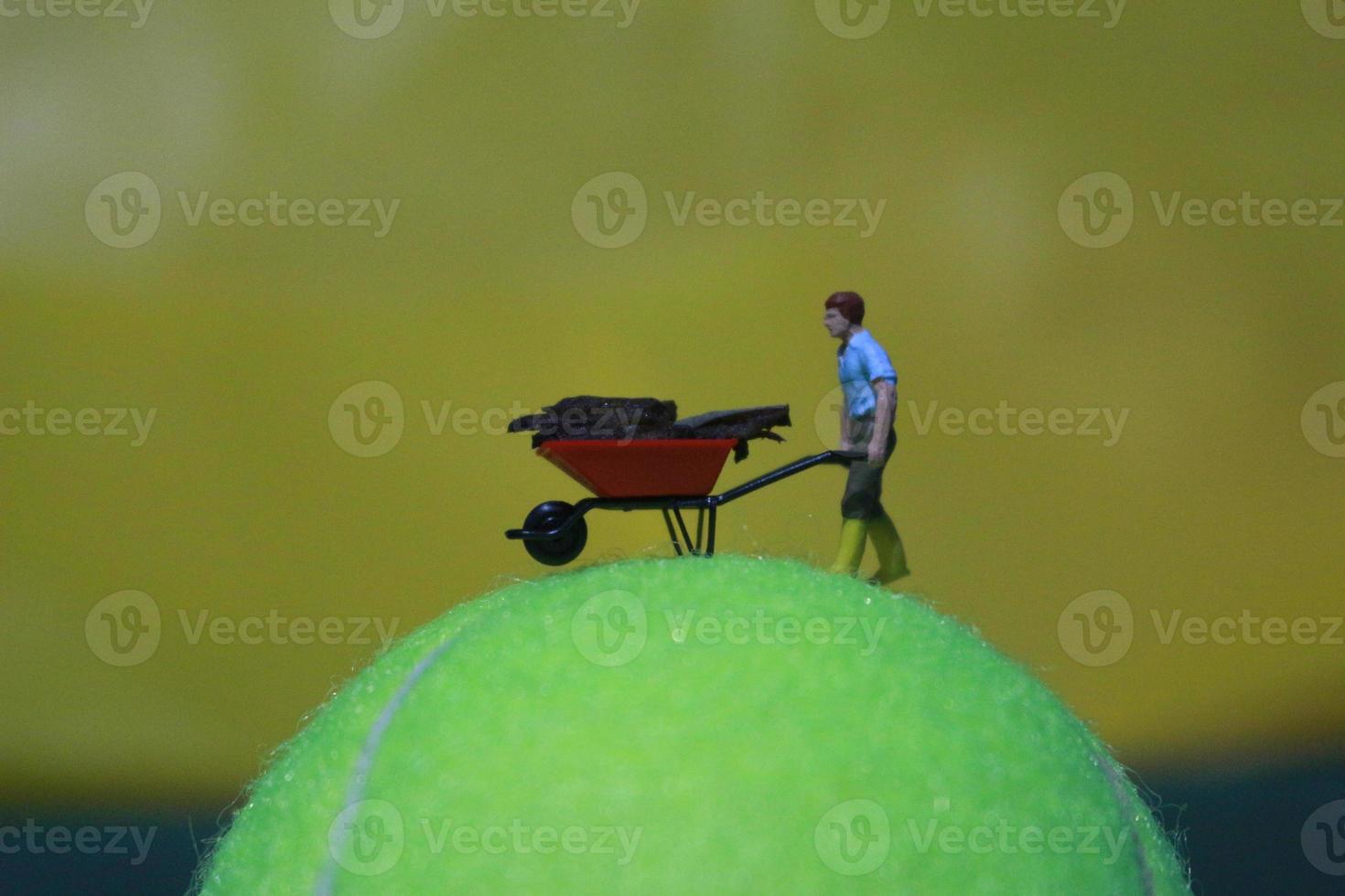 miniature figure of a female farmer working the land with a sunrise background. photo