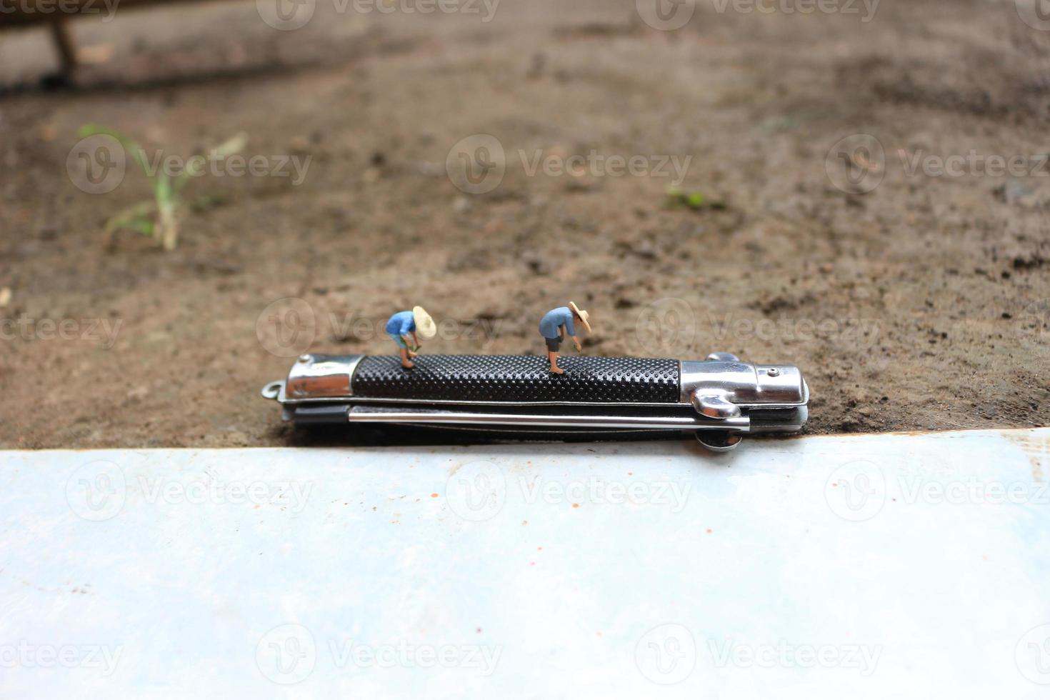 miniature figures of farmers at work on a switchblade comb. concept of agriculture photo. photo