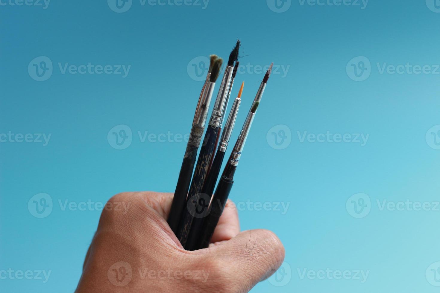 a close up of a hand holding a painting brush photo