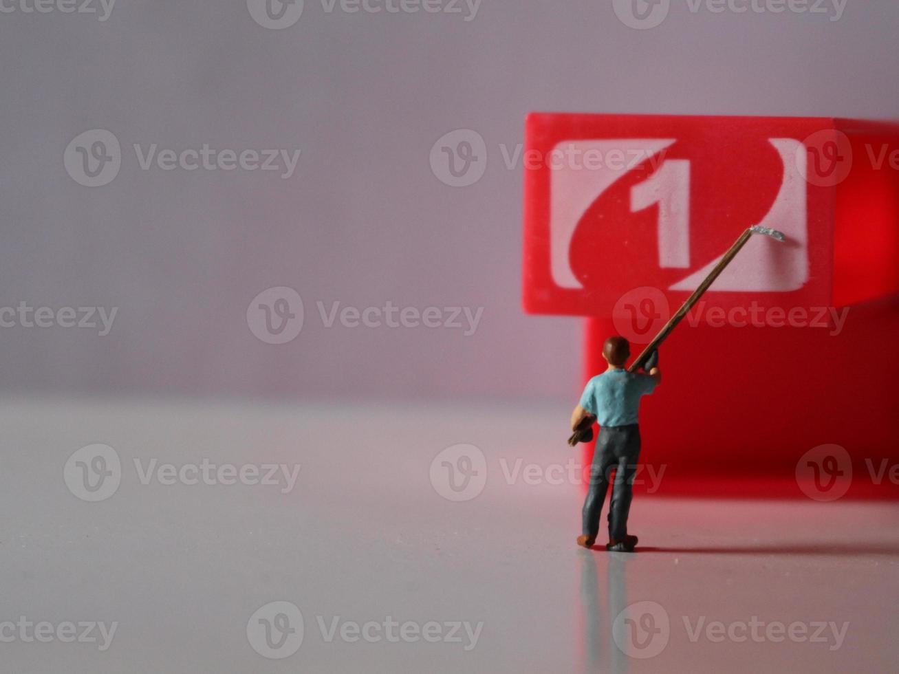a close up of miniature figures of workers coloring objects by numbers. Coloring photo concept.