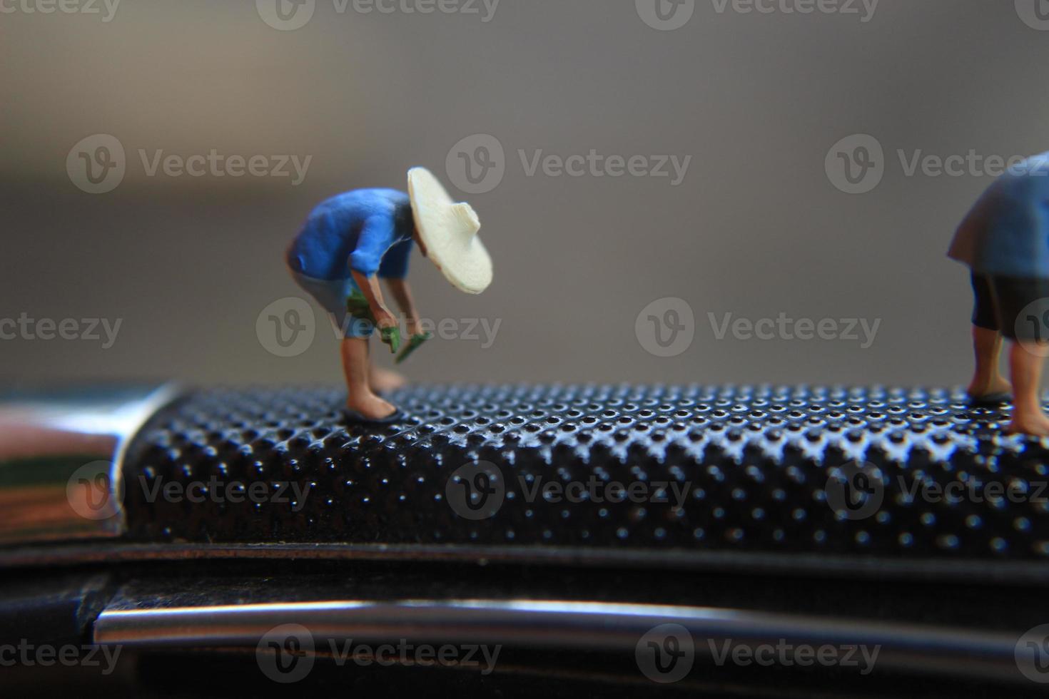 miniature figures of farmers at work on a switchblade comb. concept of agriculture photo. photo