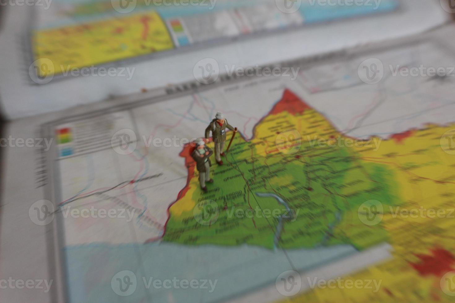 miniature figure of an explorer posing on a map or atlas photo