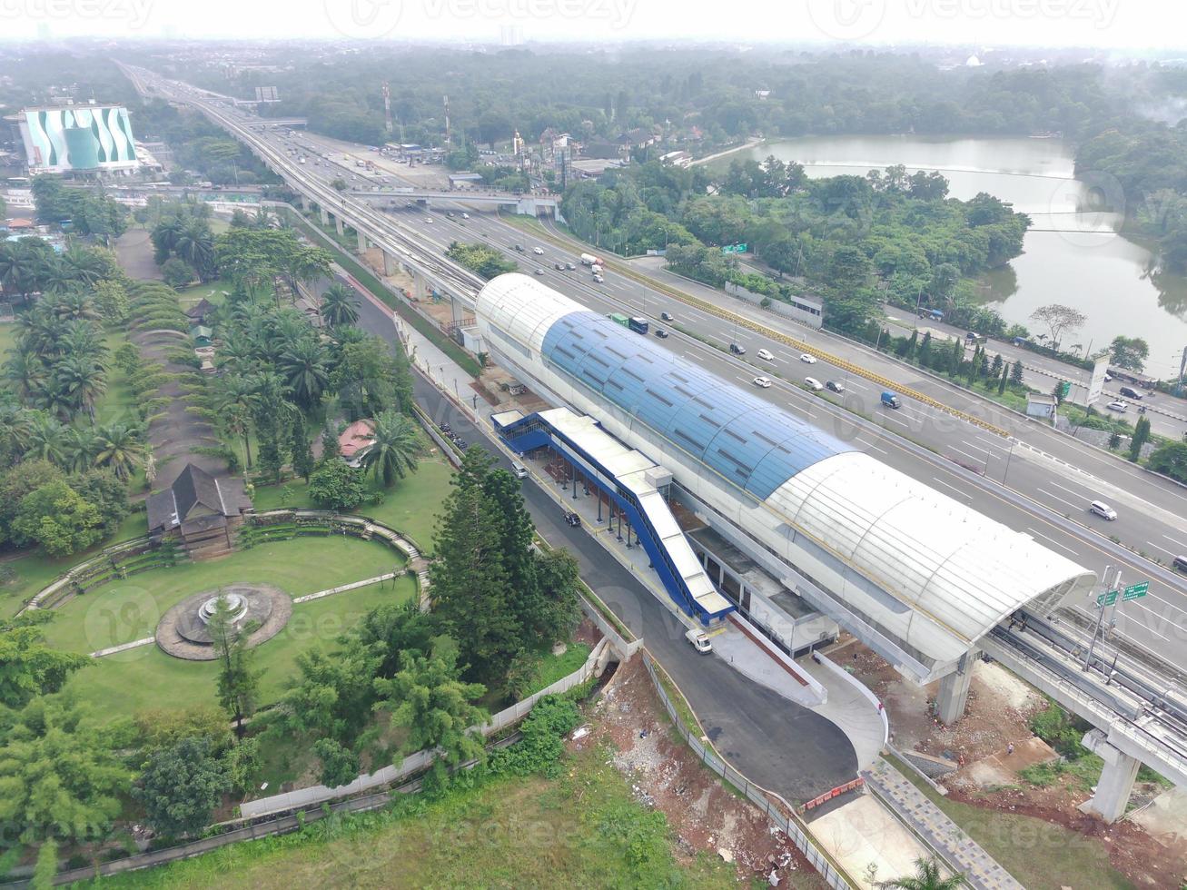 aéreo ver de un lrt estación debajo construcción, encima el Autopista y siguiente a un parque. foto