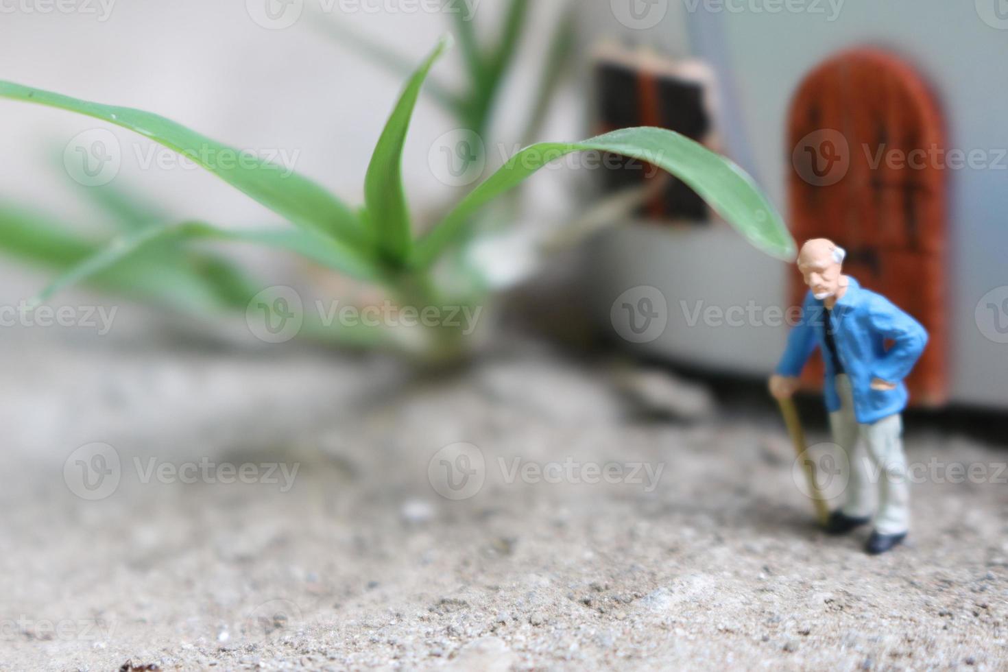 miniature figure of a grandfather who is waiting in front of the house. photo