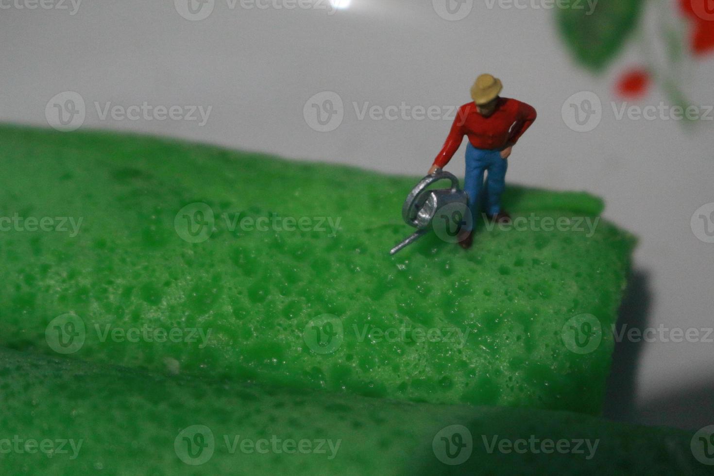 miniature figures of farmers at work on green pancake rolls. concept of agriculture photo. photo