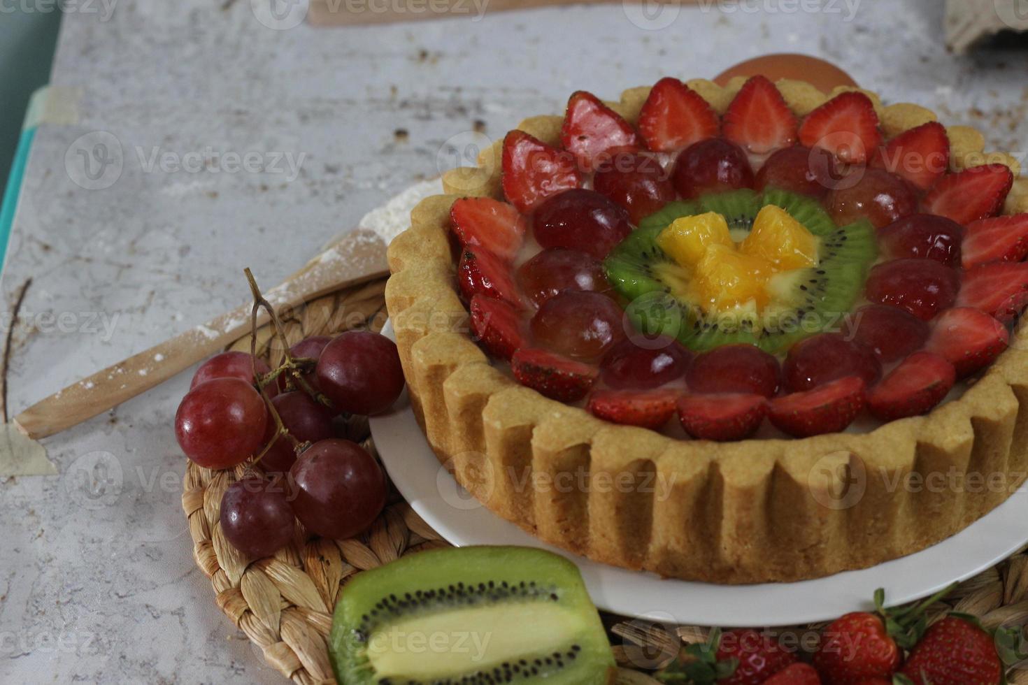 big fruit pie with toppings of strawberries, grapes, kiwi and pineapple. savory, sweet and fresh. Food concept photo. photo