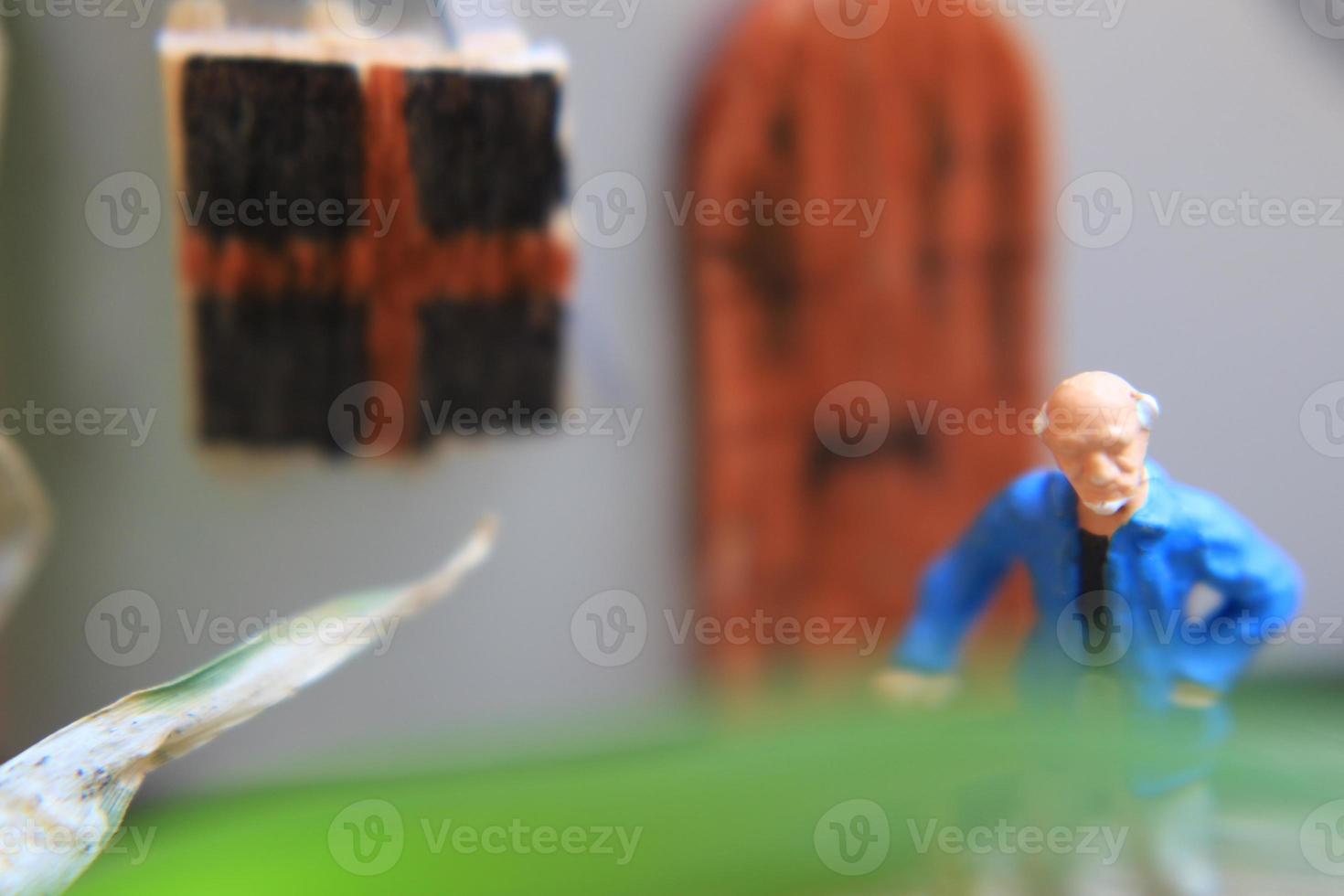 miniature figure of a grandfather who is waiting in front of the house. photo