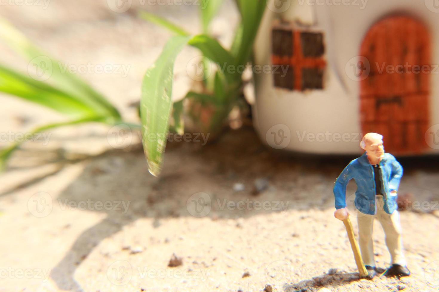 miniature figure of a grandfather who is waiting in front of the house. photo