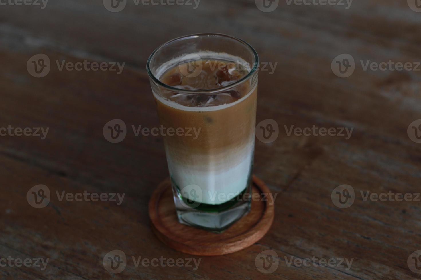 a glass of pandan coffee latte served cold on the table. photo