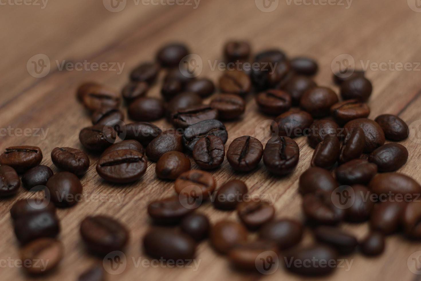 Detailed photo of coffee beans before being processed into a drink isolated on wood. Concept photo of the basic ingredients of coffee drinks.