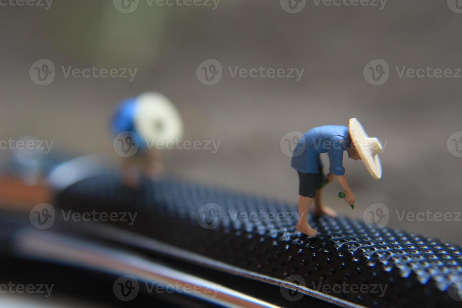 miniature figures of farmers at work on a switchblade comb. concept of agriculture photo. photo