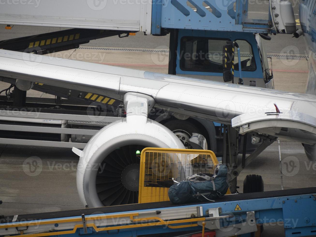 equipaje subiendo a avión mientras estacionamiento a el terminal foto