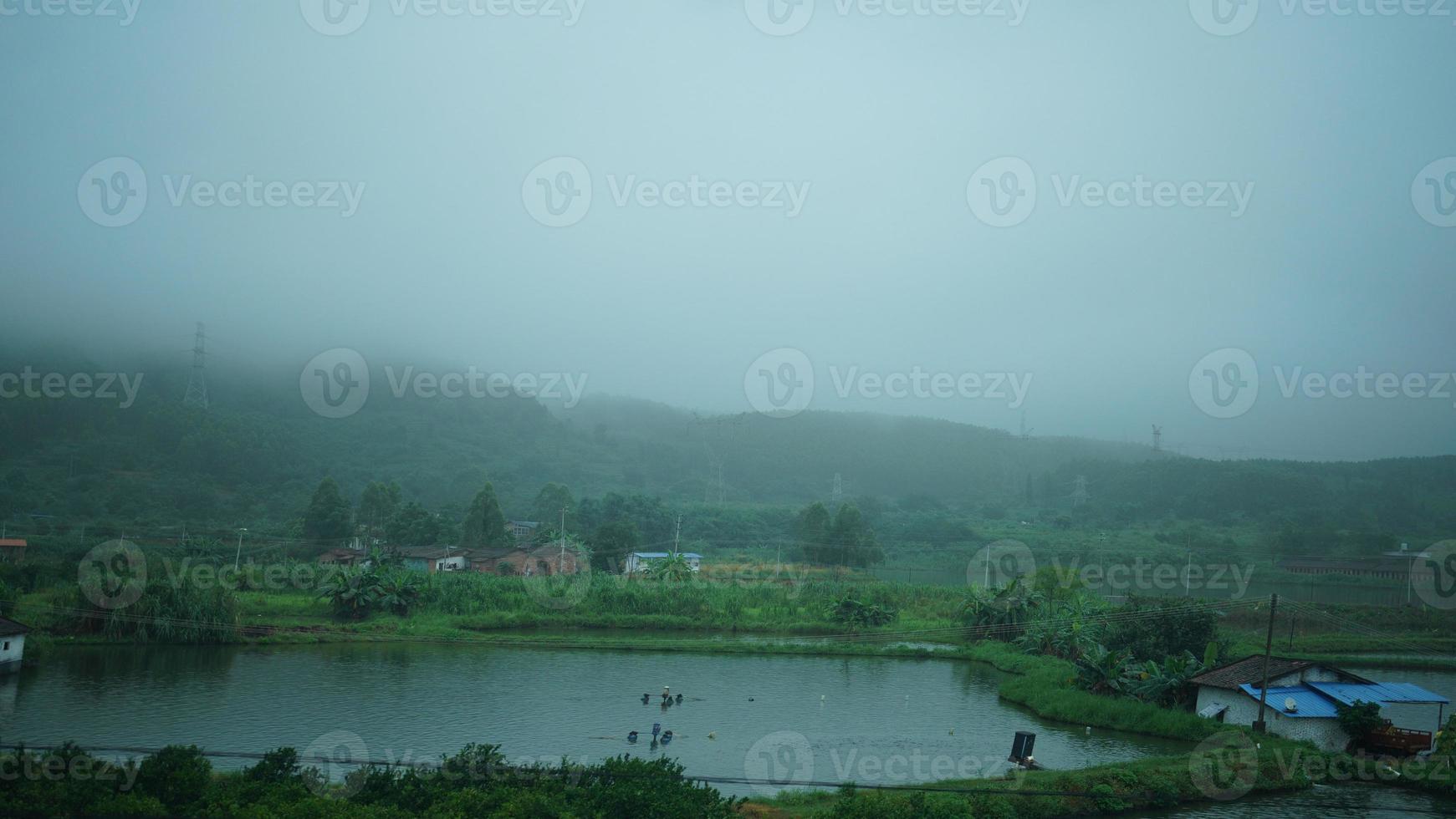 The beautiful countryside view from the runny train on the south of the China in the rainy day photo