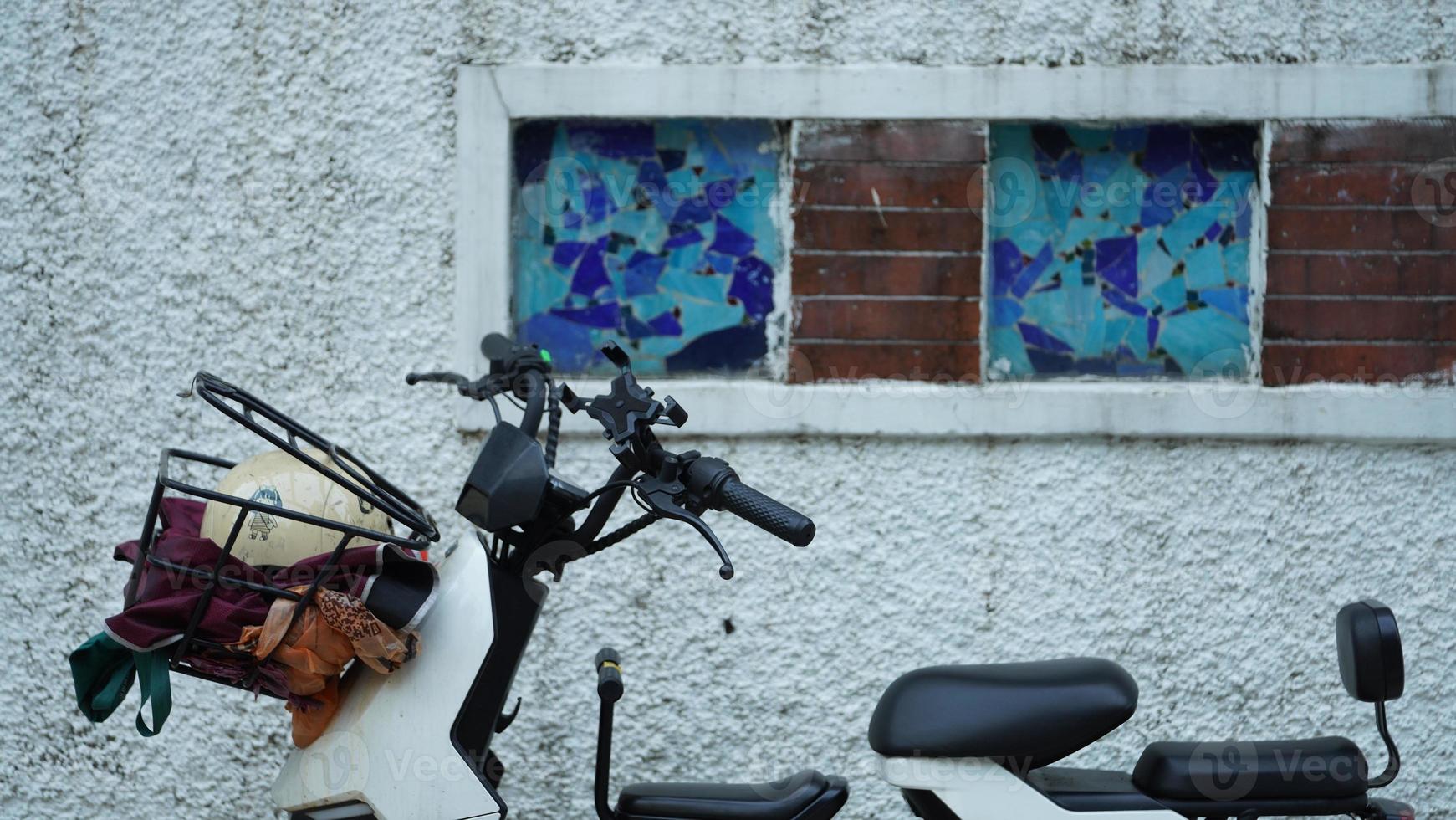 One electronic bike stopped near the wall of the old building in the city photo