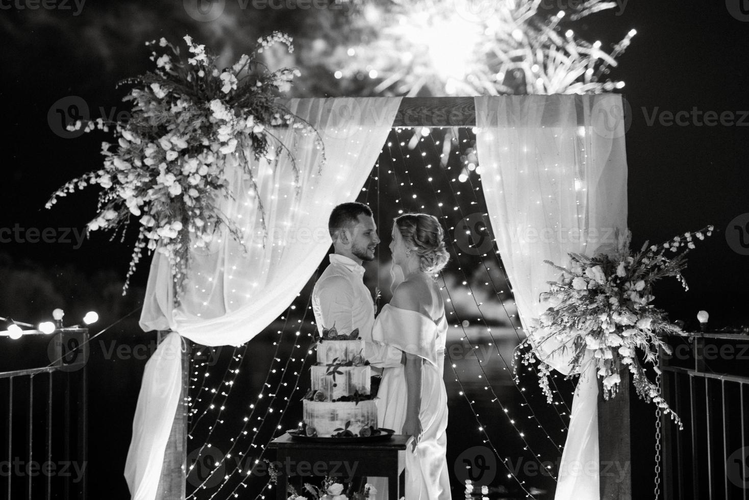 los recién casados felizmente cortan y prueban el pastel de bodas foto