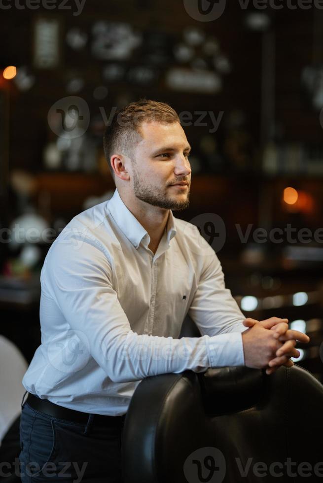 portrait of a young guy groom at the training camp in the barbershop photo