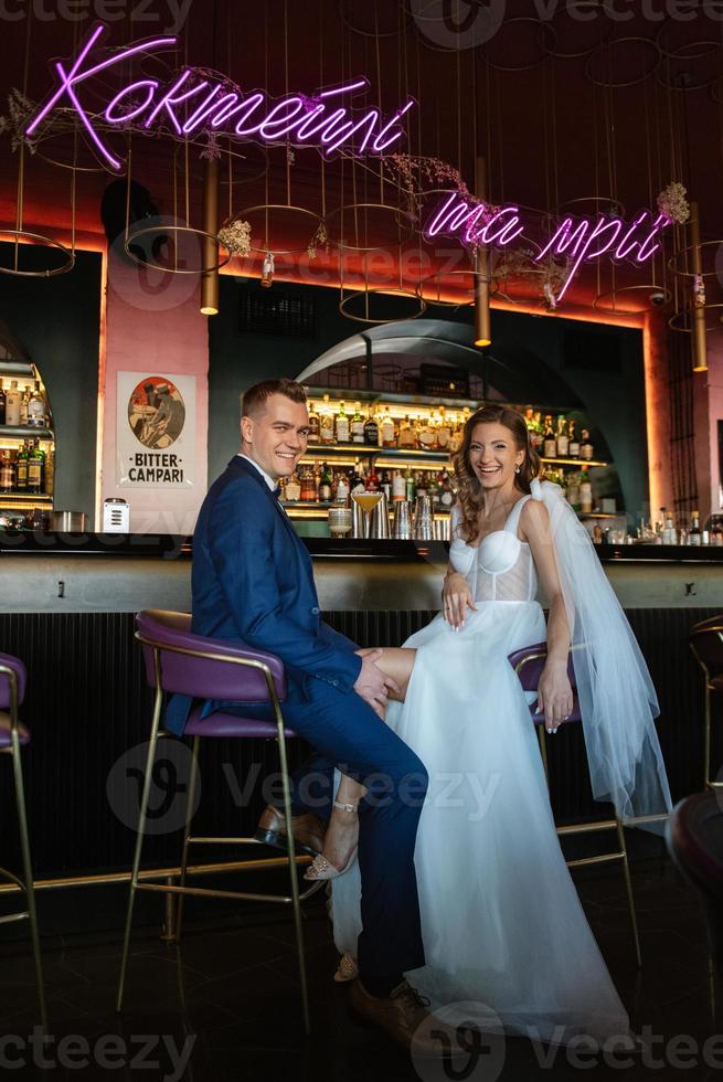 bride and groom inside a cocktail bar photo